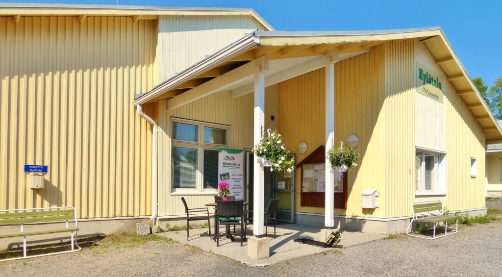 Keltainen kylätalo aurinkoisena päivänä